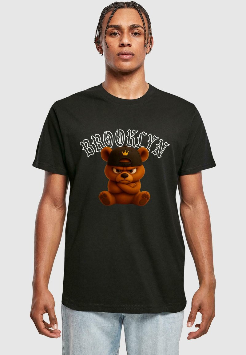 Mustad must t-särk, millel on keskel karikatuurne pruun karu, kellel on peas müts ja kroon, ning valged, kaarjad tähed sõnaga "BROOKLYN".