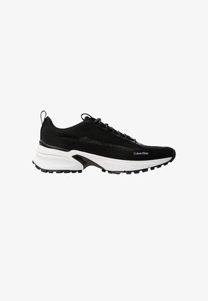 Μαύρο αθλητικό παπούτσι Calvin Klein με λευκή, παχιά σόλα, υφαντό επάνω μέρος με υφή, μαύρα κορδόνια και θηλιές στην φτέρνα και στη γλώσσα.