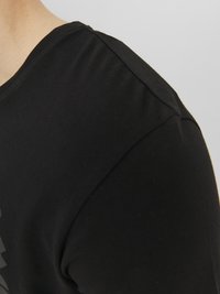 Black t-shirt with short sleeves, made of smooth fabric. Features a round neckline and minimalistic design without visible logos or patterns.