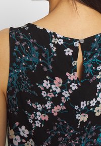 Vestido negro floral con un vibrante estampado de flores en rosa y verde azulado, abertura en la espalda en forma de llave y cierre con botón metálico.
