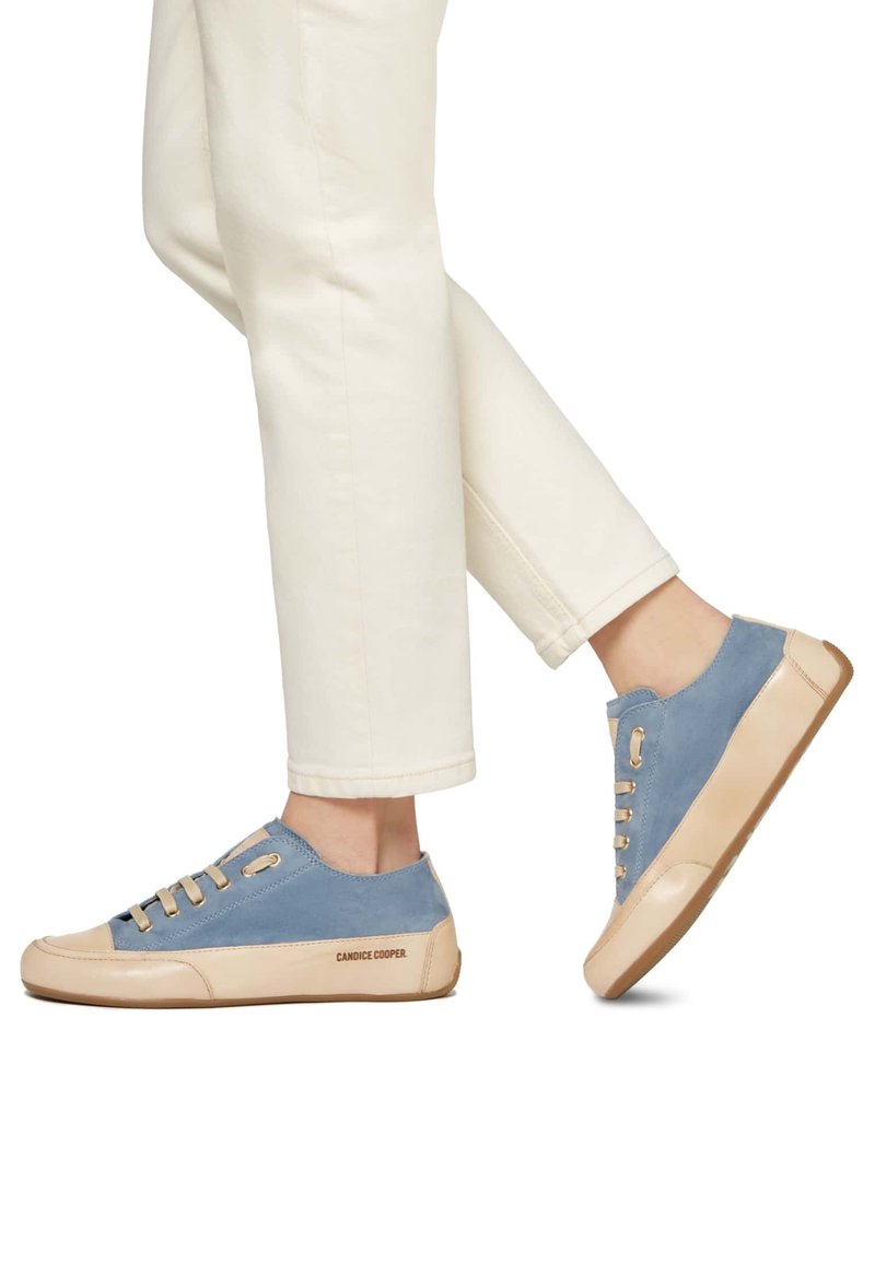 Helles blaues Wildleder Sneaker mit beigen Akzenten und Schnürsenkeln, ausgestattet mit einer Gummisohle und dem Markennamen "Candice Cooper" an der Seite.