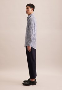 Blauw hemd met paisleypatroon, gemaakt van lichtgewicht stof, gecombineerd met donkere broeken en zwarte schoenen, met een slanke pasvorm en lange mouwen.