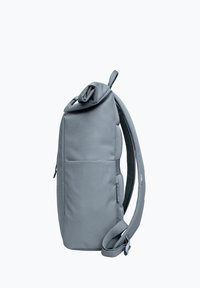 Gray backpack with a textured surface, roll-top closure, adjustable straps, and side zipper pocket. Minimalist design, compact shape.