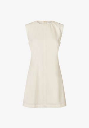 Hihaton, A-linja mekko vaaleassa beessissä kankaassa, jossa on sileä rakenne. Ominaisuuksiin kuuluu takakiinnitysvetoketju ja minimalistinen muotoilu, ilman kuvioita tai koristeita.