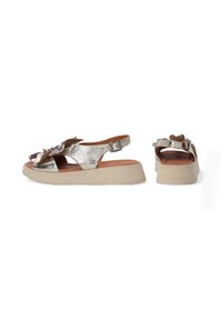 Metalen zilveren sandalen met een zacht bruine accent, met een open teen, verstelbare riem en een gestructureerde platformzool.