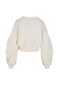 Sudadera recortada en beige claro con mangas abullonadas y fruncidas y dobladillo acanalado. Tejido de algodón suave con textura lisa.