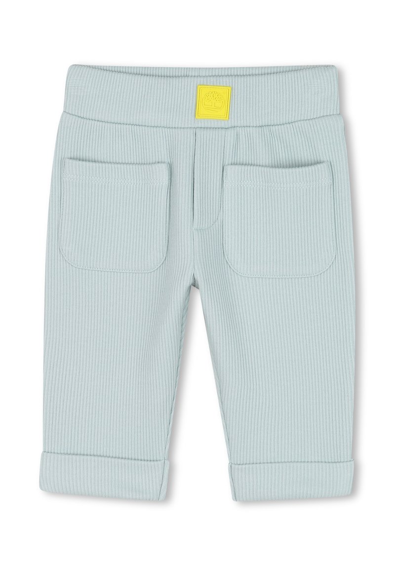 Lichtblauwe geribde broek met een zachte textuur, voorzien van een gele logo-patch, twee achterzakken en opgerolde mouwen.