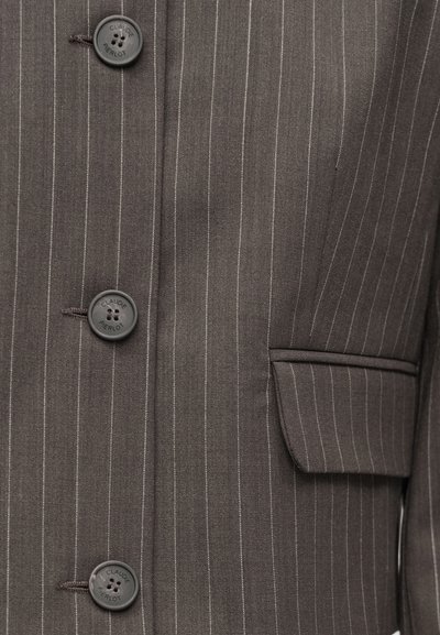 Szürke tűcsíkos blézer hat fekete gombbal, lehajtós zsebbel és testre szabott szabással. Az anyag sima textúrájú.