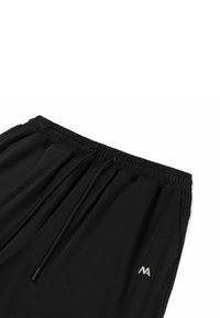 Zwarte sportbroek met een elastische tailleband, trekkoordsluiting en een klein grijs logo aan de zijkant. Soepele stoftextuur.