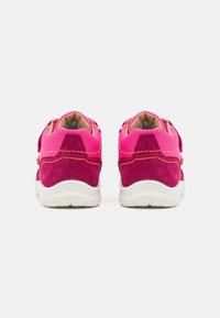 Różowe zamszowe i siateczkowe sneakersy z kontrastującymi ciemnoróżowymi akcentami. Posiadają białą podeszwę i podwójne zapięcia na rzep.