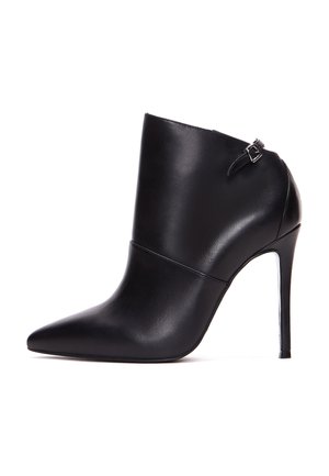 Bottine en cuir noir avec un bout pointu, un haut talon aiguille et une sangle latérale avec une boucle. Texture lisse et design épuré.
