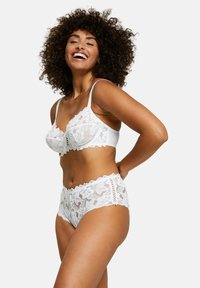 Set di reggiseno in pizzo bianco e culotte a vita alta con motivi floreali, bordi a scallop e spalline regolabili, che mettono in risalto trame delicate.