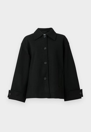 Fekete, gombos dzseki, terjedelmes gallérral, széles ujjakkal és két oldalsó zsebbel. Az anyag textúrált és puha hatású.