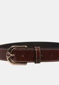 Cintura in pelle marrone con fibbia in metallo dorato lucido, cuciture bianche e diversi fori di regolazione su un lato inferiore in nero liscio.