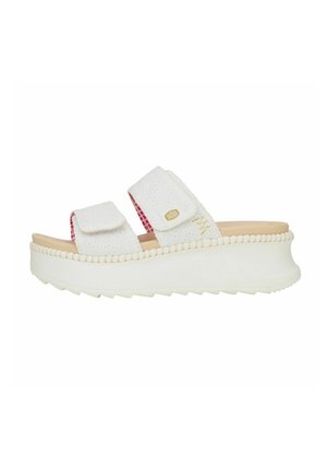 Sandali platform bianchi con due cinturini regolabili in Velcro, tomaia testurizzata e una fodera a scacchi rosa. Presentano una suola spessa in gomma con un motivo ondulato.