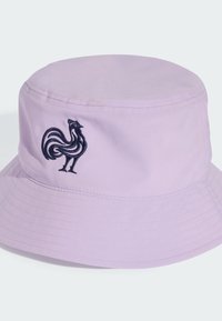 Cappello a secchiello lavanda con la parte superiore rotonda e la visiera larga, caratterizzato da un design di gallo ricamato in nero sulla parte anteriore. Tessuto morbido.