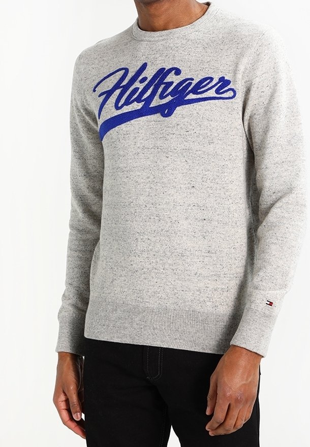 Szary sweter dzianinowy z okrągłym dekoltem, z niebieskim haftowanym logo "Hilfiger" na przodzie. Dodatkowo, ribbowe mankiety i dolny brzeg.