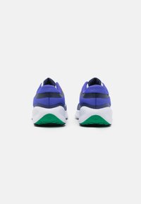 Baskets de sport violettes et marines avec une semelle extérieure blanche et verte. Tige en mesh avec des accents texturés et un design de talon arrondi.