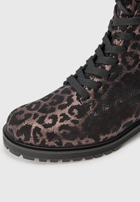 Schwarze Knöchelstiefel mit einem metallischen Leopardenmuster, ausgestattet mit einer strukturierten Oberfläche, einer stabilen schwarzen Sohle und schwarzen Schnürsenkeln.