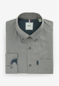Chemise grise à manches longues boutonnée, pliée, avec col boutonné et doublure intérieure bleu marine à pois blancs, étiquetée "Next Tailoring."