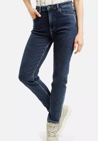 Ciemnoniebieskie dżinsy z wysokim stanem, prostymi nogawkami i prostym przeszyciem. Posiadają pięć kieszeni i klasyczny zamek na guziki.