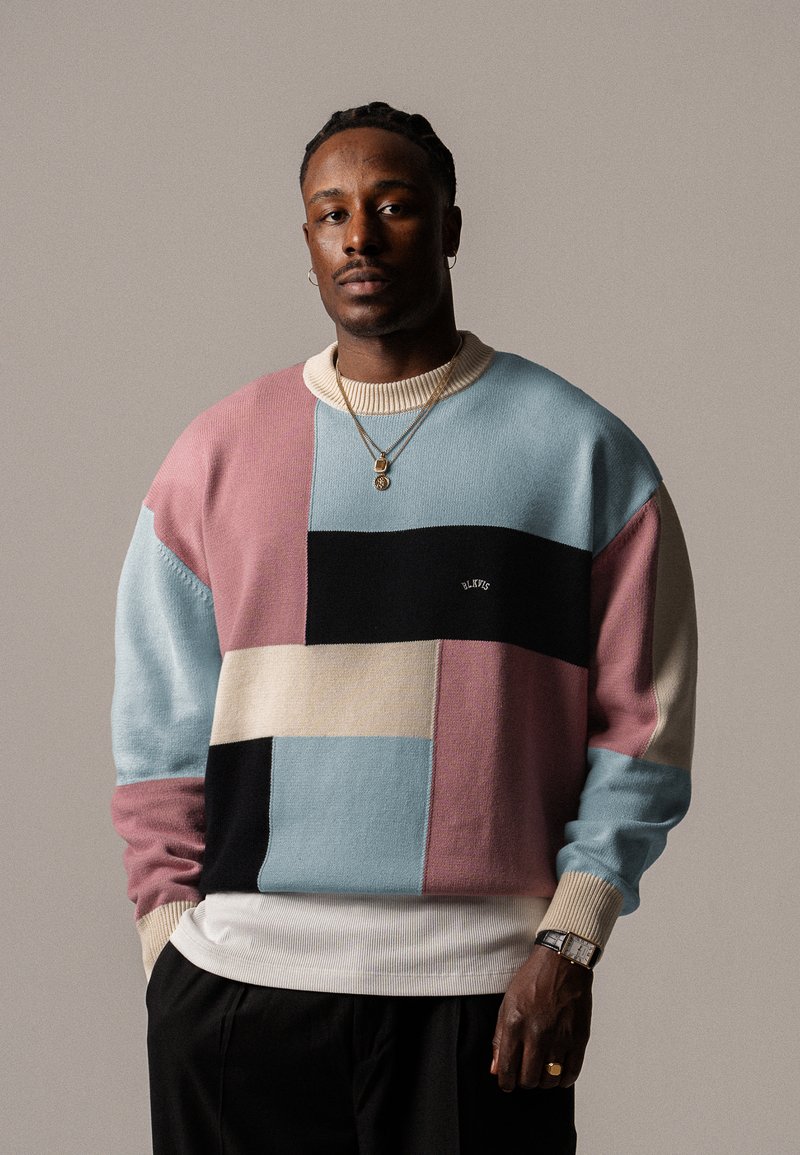 Maglione a blocchi di colore con tonalità pastello di blu, rosa, nero e beige. Texture a maglia con colletto e polsini a coste. Dettaglio logo ricamato.