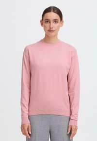 Rosa stickad tröja med lång ärm, rund halsringning och ribbade detaljer vid ärmbladen och nederkant. Slät textur, avslappnad passform.