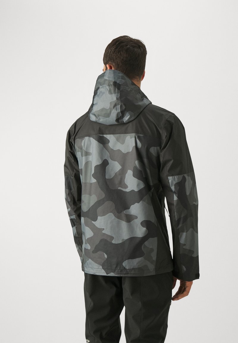Chaqueta impermeable en un patrón de camuflaje negro y gris, con capucha, mangas largas y tejido suave y texturizado.