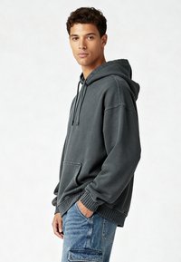 Felpa con cappuccio grigio scuro, dotata di tasca frontale, cappuccio regolabile con cordino e polsini a costine. Tessuto morbido con vestibilità rilassata.