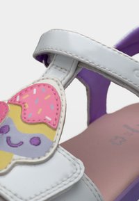 Λευκές σανδάλες από λουστρίνι με μοβ σόλες, διακοσμημένες με πολύχρωμο σχέδιο παγωτού σε χωνάκι στο λουρί, με λεπτομέρειες ραφής και χαμογελαστά προσωπάκια.