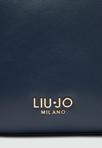 Borsa in pelle strutturata blu navy con logo LIU JO MILANO in tonalità oro. Finitura liscia, forma rettangolare e dettagli in rilievo discreti.