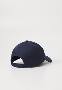 Navy blue cap with a curved brim, adjustable strap at the back, textured fabric, and vent holes on the sides for breathability.