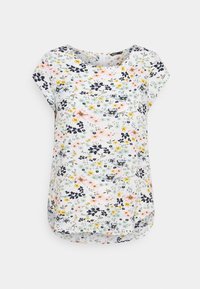 Blusa a stampa floreale con maniche corte, scollatura rotonda e orlo curvo. I colori includono bianco, blu navy, rosa e giallo con vari motivi floreali.