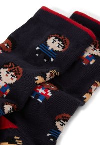 Calcetines de punto en azul marino, con diseños de personajes pixelados en varios colores. Puño con acento rojo. El material parece suave y texturizado.