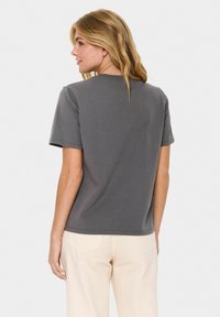 Grå kortärmad t-shirt i bomull med rund halsringning och avslappnad passform, synlig sömnad och en slät, mjuk textur.