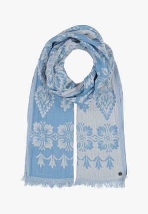 Világoskék sál fehér virágmintákkal és rojttal mindkét végén, lazán összehajtva, a bojt közelében egy kis kerek fém címkével.