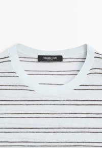 Pull en maille blanc avec de fines rayures horizontales noires et un col rond, avec une étiquette noire Massimo Dutti au col.