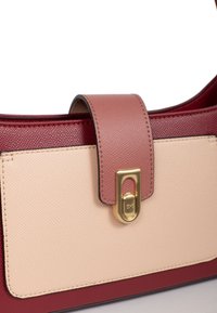Borsa in pelle con pannelli texturizzati rosa e beige, hardware dorato e chiusura magnetica. Presenta un design strutturato e colori a contrasto.