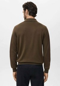 Polo de manga larga tejido en marrón con cuello y puños acanalados, que presenta una textura suave y una silueta ajustada.