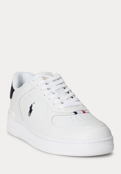 Λευκό χαμηλό αθλητικό παπούτσι με μαύρη λεπτομέρεια στη φτέρνα, διάτρητη μύτη, κορδόνια και μικρές κόκκινες, άσπρες και μπλε ρίγες στο μπροστινό επάνω μέρος.