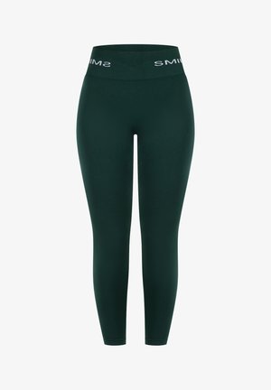 Dunkelgrüne Leggings mit einem hohen Bund und weißem "SMIM"-Schriftzug. Hergestellt aus dehnbarem, glattem Material, figurbetont entlang der Beine.