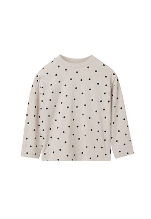 Lichtbeige shirt met lange mouwen en zwarte stippen. Ronde hals, zachte katoenen stof, relaxte pasvorm. Geen zichtbare etiketten of extra details.