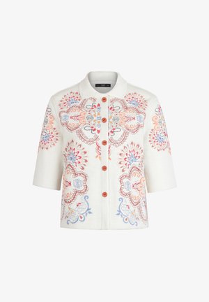 Valge lühikeste varrukatega jakk värvilise lillemustrilise tikkimisega ja pruunide esiekraanil asuvate nuppudega.