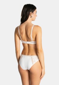 Ensemble de lingerie avec finition en dentelle blanche comprenant un soutien-gorge à bretelles réglables et une culotte taille haute assortie ornée d'accents en dentelle florale.