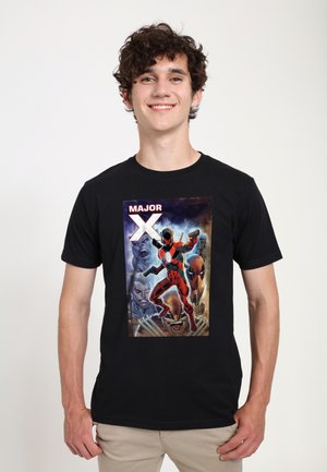 Sort T-shirt med et farverigt tegneserie-design, hvor en figur i rød og sort holder pistoler, samt teksten "MAJOR X" ovenfor.