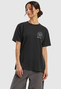 Black cotton t-shirt featuring a front graphic of a flower and text "Take it easy," with short sleeves and a relaxed fit.
