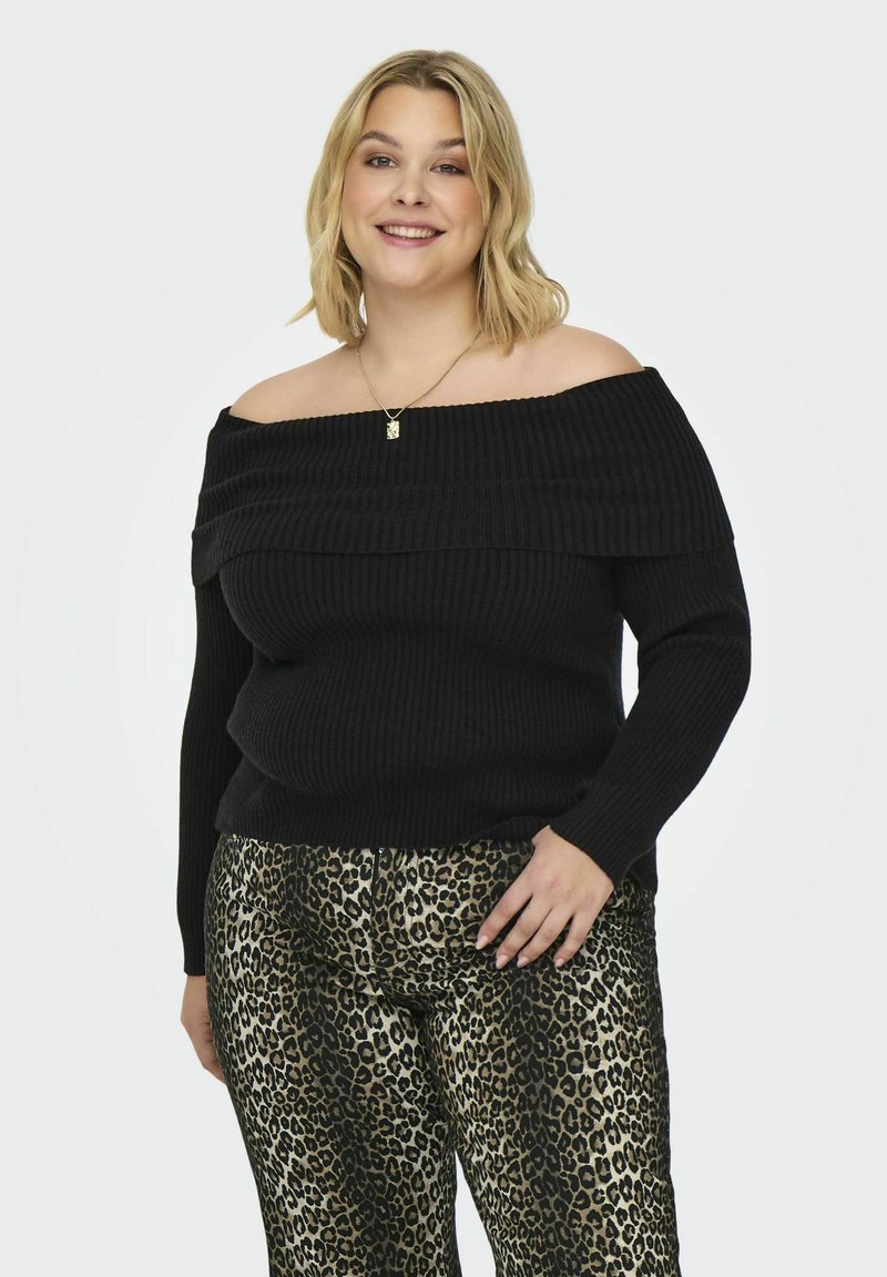 Zwarte off-shoulder geribde trui met lange mouwen, gecombineerd met metallic dierenprintbroek met een gouden en zwarte luipaardpatroon.
