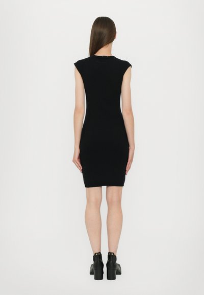 Rochie neagră ajustată cu măneci scurte, de lungime până la genunchi. Țesătură netedă, design minimalist. Purtați cu botine negre cu tocuri. Vedere din spate.