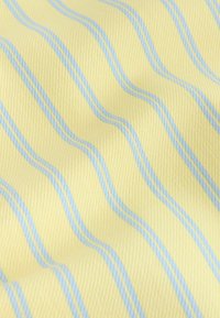 Tissu jaune à texture douce avec des rayures verticales ondulées bleu clair régulièrement espacées, plié doucement créant des ombres subtiles.