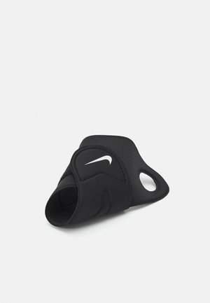 Black neoprene wrist support with ergonomic design, featuring a cutout for thumb and a white Nike logo. Smooth texture with adjustable strap.